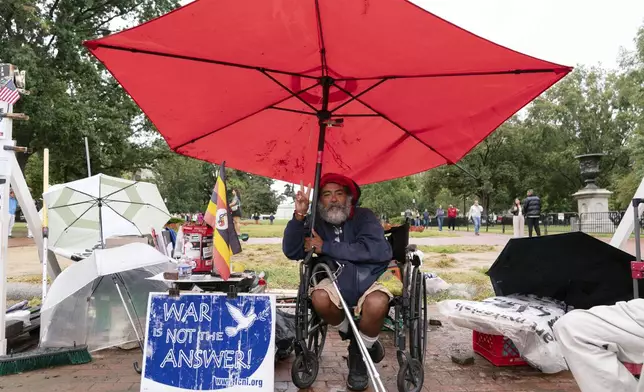 Philipos Melaku-Bello flashes the V sign during Peace Vigil in Lafayette Park across from the White House in Washington, Sunday, Sept. 7, 2025. (AP Photo/Jose Luis Magana)