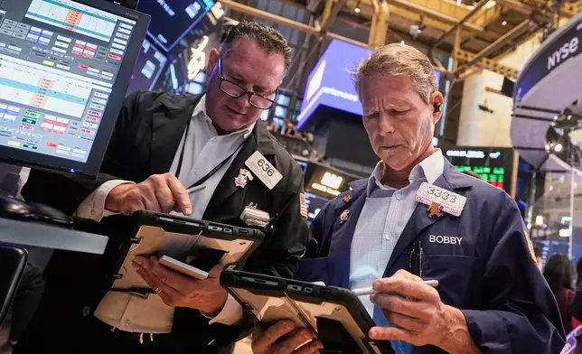 Traders Edward Curran, left, and Robert Charmak work on the floor of the New York Stock Exchange, Wednesday, Sept. 17, 2025. (AP Photo/Richard Drew)