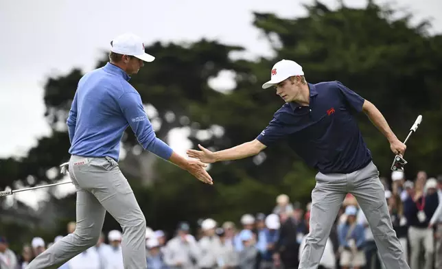 The Great Britain and Ireland team's Connor Graham, right, shakes hands with Tyler Weaver after sinking a putt on the 14th green during Walker Cup golf matches against the USA team at Cypress Point Club on Saturday, Sept. 6, 2025, in Pebble Beach, Calif. (AP Photo/Thien-An Truong)