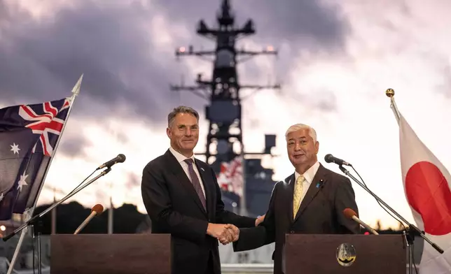 Japan's Defence Minister Gen Nakatani, right, and Australia's Defence Minister Richard Marles shake hands following a joint press announcement aboard the Japan Maritime Self-Defense Force (JMSDF) Mogami-class stealth frigate JS Mikuma at the JMSDF naval base in Yokosuka, Japan, Friday Sept. 5, 2025. (Yuichi Yamazaki/Pool Photo via AP)