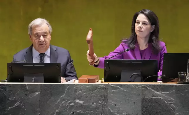 UN General Assembly President Annalena Baerbock gavels the meeting open as UN Secretary General Antonio Guterres listens during the 80th session of the United Nations General Assembly, Tuesday, Sept. 23, 2025. (AP Photo/Richard Drew)