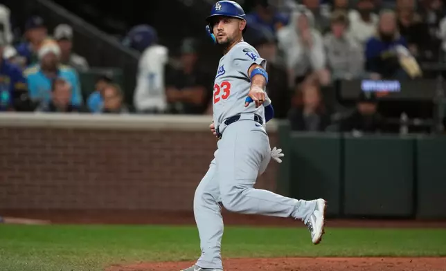 Los Angeles Dodgers' Michael Conforto gestures after scoring off a wild pitch by Seattle Mariners relief pitcher Logan Evans during the seventh inning of a baseball game, Saturday, Sept. 27, 2025, in Seattle. (AP Photo/Ryan Sun)