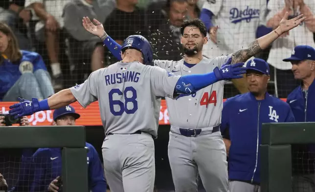 Los Angeles Dodgers' Dalton Rushing (68) celebrates with Andy Pages (44) after hitting a two-run go-ahead home run that scored Miguel Rojas during the fifth inning of a baseball game against the Seattle Mariners, Saturday, Sept. 27, 2025, in Seattle. (AP Photo/Ryan Sun)