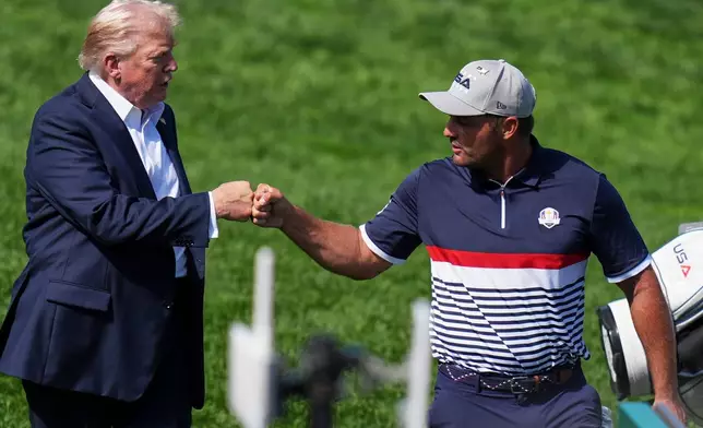 President Donald Trump greets United States' Bryson DeChambeau on the first hole at Bethpage Black golf course during the Ryder Cup golf tournament, Friday, Sept. 26, 2025, in Farmingdale, N.Y. (AP Photo/Seth Wenig)