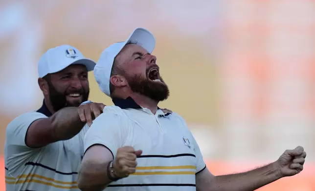Europe's Shane Lowry celebrates with Jon Rahm after making the winning putt on the 18th hole during their singles match on the Bethpage Black golf course at the Ryder Cup golf tournament, Sunday, Sept. 28, 2025, in Farmingdale, N.Y. (AP Photo/Seth Wenig)