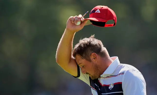 United States' Bryson DeChambeau wipes his face on the fifth hole during their singles match on the Bethpage Black golf course at the Ryder Cup golf tournament, Sunday, Sept. 28, 2025, in Farmingdale, N.Y. (AP Photo/Robert Bukaty)