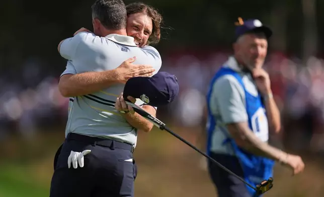 Europe's Tommy Fleetwood and Rory McIlroy celebrate their win on the 14th hole at Bethpage Black golf course during the Ryder Cup golf tournament, Friday, Sept. 26, 2025, in Farmingdale, N.Y. (AP Photo/Seth Wenig)