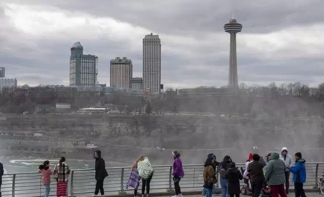 FILE - Tourists on the American side of Niagara Falls take photos in Niagara Falls, N.Y. on March 29, 2024. (Carlos Osorio/The Canadian Press via AP, file)