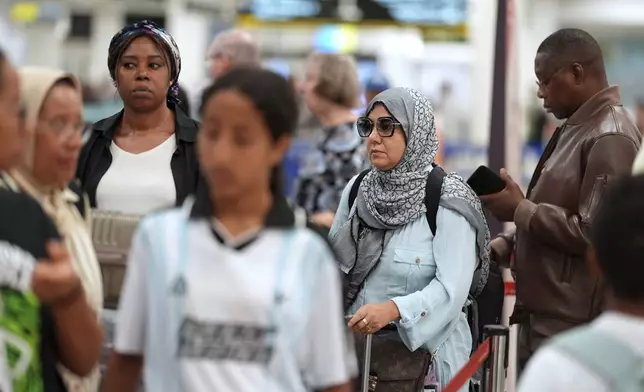 Travelers check in for international flights in the Miami International Airport at the start of the Labor Day weekend, Friday, Aug. 29, 2025, in Miami. (AP Photo/Rebecca Blackwell)