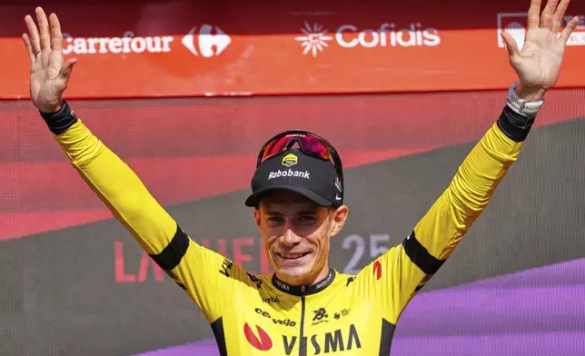 Danish rider Jonas Vingegaard, from Visma | Lease a Bike team celebrates at the podium after wining the ninth stage of La Vuelta from Alfaro to Valdezcaray, Spain, Sunday, Aug. 31, 2025. (AP Photo/Miguel Oses)