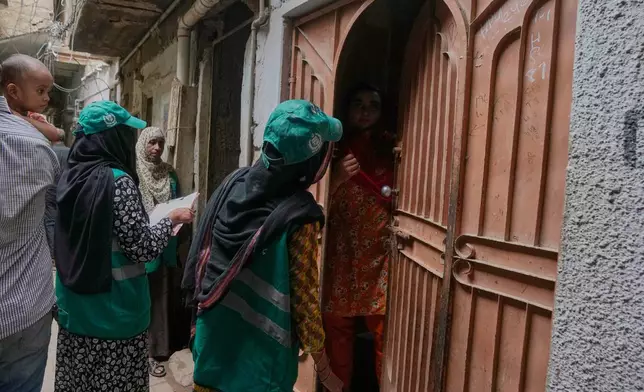 A heath worker talks with a woman during a human papillomavirus (HPV) vaccination campaign aiming to protect girls from cervical cancer, at a neighbourhood of Karachi, Pakistan, Wednesday, Sept. 24, 2025. (AP Photo/Fareed Khan)