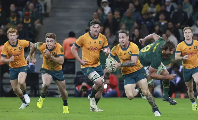 Australia's Corey Toole, front, breaks away from South Africa's Eben Etzebeth during a rugby championship test match between South Africa and Australia, at Cape Town stadium in Cape Town, South Africa, Saturday, Aug. 23, 2025. (AP Photo/Halden Krog)