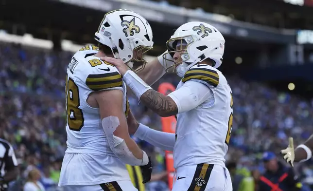 New Orleans Saints tight end Jack Stoll (88) celebrates his touchdown reception with quarterback Spencer Rattler in the second half of an NFL football game against the Seattle Seahawks, Sunday, Sept. 21, 2025, in Seattle. (AP Photo/Lindsey Wasson)