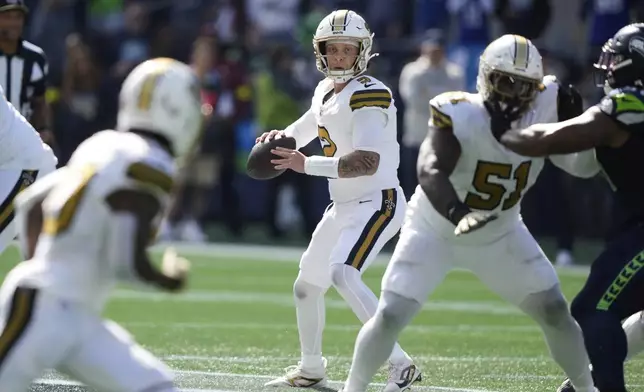 New Orleans Saints quarterback Spencer Rattler (2) drops back to pass during the first half of an NFL football game against the Seattle Seahawks, Sunday, Sept. 21, 2025, in Seattle. (AP Photo/Stephen Brashear)