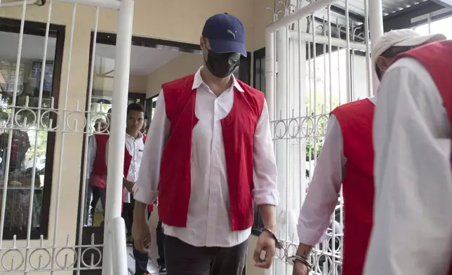 Ukraine's citizen Roman Nazarenko, center, who is on trial on accusation of running a drug lab on the resort island of Bali, arrives for a hearing at the district court in Denpasar, Indonesia, Thursday, Sept. 18, 2025. (AP Photo/Firdia Lisnawati)