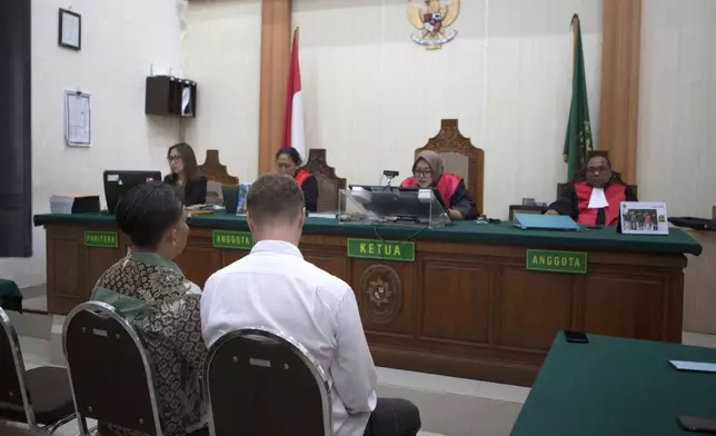 Ukraine's citizen Roman Nazarenko, centre back to the camera, who is on trial on accusation of running a drug lab on the resort island of Bali, attends a hearing at the district court in Denpasar, Indonesia, Thursday, Sept. 18, 2025. (AP Photo/Firdia Lisnawati)