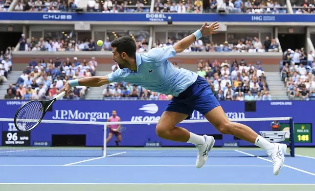 Novak Djokovic, of Serbia, returns a shot to Carlos Alcaraz, of Spain, during the men's singles semifinals of the U.S. Open tennis championships, Friday, Sept. 5, 2025, in New York. (AP Photo/Yuki Iwamura)