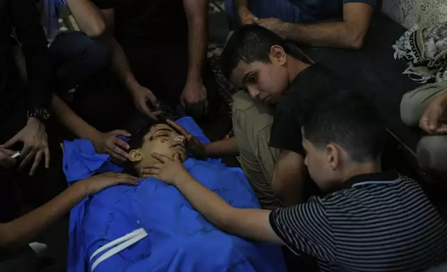 Qassam, 11, center takes the last look at his brother Islam Majarmeh, one of two 14-year-old Palestinian boys who were killed in the Jenin refugee camp on Monday, during his funeral in the Israeli occupied West Bank city of Jenin Tuesday, Sept. 9, 2025. (AP Photo/Nasser Nasser)