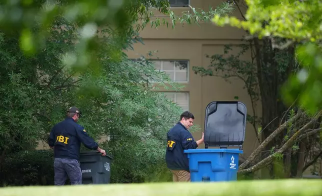 FBI agents look around a home in Fairview, Texas, that public records link to a suspected gunman at a U.S. Immigration and Customs Enforcement office in Dallas, on Wednesday, Sept. 24, 2025. (AP Photo/Julio Cortez)