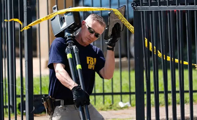 FBI agents investigate the crime scene near a U.S. Immigration and Customs Enforcement office Thursday, Sept. 25, 2025, in Dallas. (AP Photo/Tony Gutierrez)