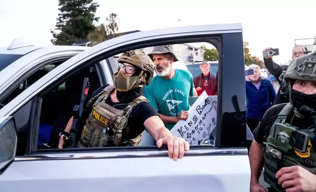 Protesters confront U.S. Border Patrol personnel as they try to enter Coast Guard Base Alameda on Thursday, Oct. 23, 2025, in Oakland, Calif. (AP Photo/Noah Berger)