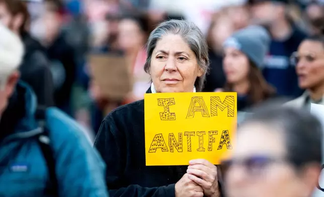 Max Ventura holds a sign reading "I AM ANTIFA" while protesting against immigration raids in San Francisco on Thursday, Oct. 23, 2025. (AP Photo/Noah Berger)