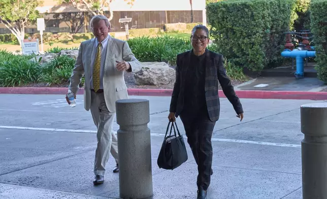 Shawn Holley, right, and Rusty Hardin, attorneys for the family of former baseball pitcher Tyler Skaggs, arrive during the trial for the wrongful death lawsuit accusing the Los Angeles Angels baseball team of being responsible for the 2019 drug overdose death of Skaggs Tuesday, Oct. 21, 2025, in Santa Ana, Calif. (AP Photo/Gregory Bull)