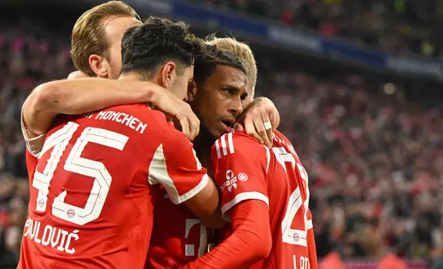 Bayern's Michael Olise, centre, celebrates with teammates after scoring his side's second goal during the Bundesliga soccer match between Bayern Munich and Borussia Dortmund in Munich, Germany, Saturday, Oct. 18, 2025. (AP Photo/Lennart Preiss)