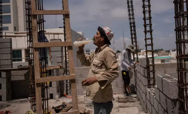 FILE - Jorge Moreno, a worker, drinks flavored water to cope with the heat wave during his workday at a construction site in Veracruz, Mexico, June 17, 2024. (AP Photo/Felix Marquez, File)