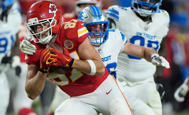 Kansas City Chiefs tight end Travis Kelce, left, gains a first down before being brought down by Detroit Lions linebacker Jack Campbell, right, during the second half of an NFL football game Sunday, Oct. 12, 2025, in Kansas City, Mo. (AP Photo/Charlie Riedel)1