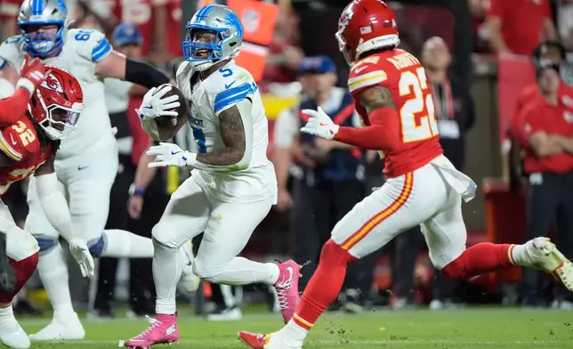 Detroit Lions running back David Montgomery, left, runs for a first down as Kansas City Chiefs cornerback Trent McDuffie (22) defends during the second half of an NFL football game Sunday, Oct. 12, 2025, in Kansas City, Mo. (AP Photo/Charlie Riedel)