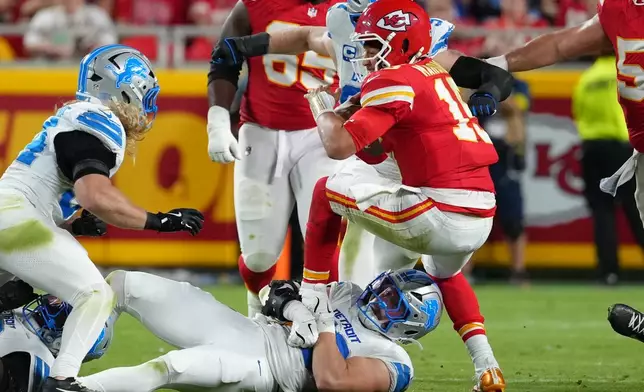 Kansas City Chiefs quarterback Patrick Mahomes, top, struggles for yardage as Detroit Lions linebacker Trevor Nowaske defends during the second half of an NFL football game Sunday, Oct. 12, 2025, in Kansas City, Mo. (AP Photo/Ed Zurga)