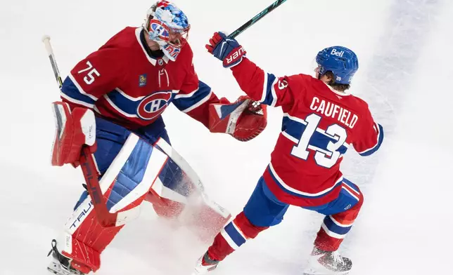 Montreal Canadiens' Cole Caufield (13) celebrates after his goal against the Nashville Predators with goaltender Jakub Dobes (75) during overtime NHL hockey game action in Montreal, Thursday, Oct. 16, 2025. (Christinne Muschi/The Canadian Press via AP)