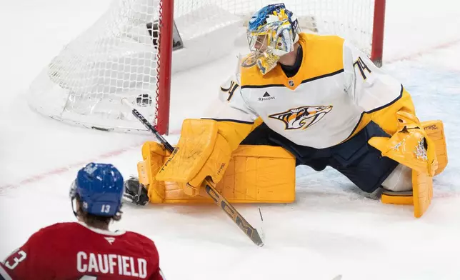 Montreal Canadiens' Cole Caufield (13) scores against Nashville Predators goaltender Juuse Saros (74) during third period NHL hockey action in Montreal on Thursday, Oct. 16, 2025. (Christinne Muschi/The Canadian Press via AP)