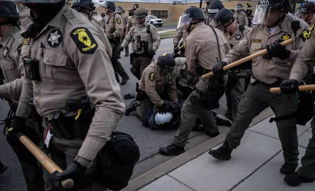 Illinois State Police move in to make detentions after declaring an unlawful assembly outside the U.S. Immigration and Customs Enforcement facility in Broadview, Ill., Saturday, Oct. 11, 2025. (AP Photo/Adam Gray)