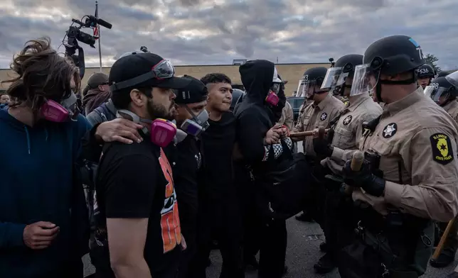 Illinois State Police move protesters back after declaring an unlawful assembly outside the U.S. Immigration and Customs Enforcement facility in Broadview, Ill., Saturday, Oct. 11, 2025. (AP Photo/Adam Gray)