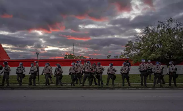Illinois State Police stand guard after declaring an unlawful assembly outside the U.S. Immigration and Customs Enforcement facility in Broadview, Ill., Saturday, Oct. 11, 2025. (AP Photo/Adam Gray)