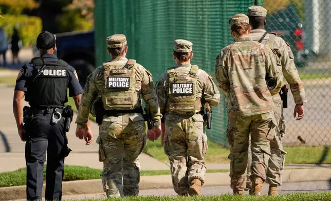 A Memphis Police Department officer, left, patrols with members of the National Guard, Friday, Oct. 10, 2025, in Memphis, Tenn. (AP Photo/George Walker IV)