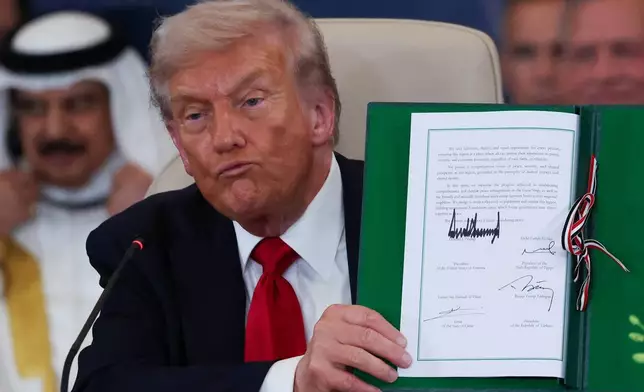 President Donald Trump holds a signed document during a summit to support ending the more than two-year Israel-Hamas war in Gaza after a breakthrough ceasefire deal, Monday, Oct. 13, 2025, in Sharm El Sheikh, Egypt. (Suzanne Plunkett/Pool via AP)