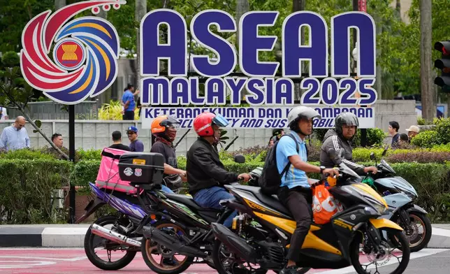 Motorists stop at a traffic light next to the logo of the Association of Southeast Asian Nations (ASEAN) in front of Malaysia's Petronas Twin Towers ahead of the 47th ASEAN Summit in Kuala Lumpur, Malaysia, Friday, Oct. 24, 2025. (AP Photo/Vincent Thian)
