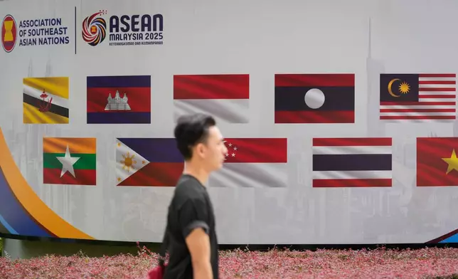 A man walks in front national flags of member nations of the Association of Southeast Asian Nations (ASEAN) ahead of the 47th ASEAN Summit in Kuala Lumpur, Malaysia, Friday, Oct. 24, 2025. (AP Photo/Vincent Thian)