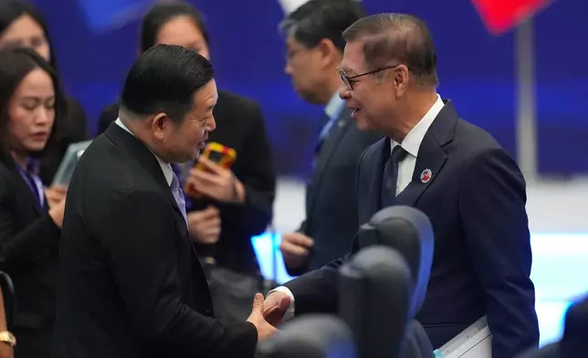 Thailand's Foreign Minister Sihasak Phuangketkeow, right, shakes hands with ASEAN Secretary-General Kao Kim Hourn as they arrive to attend the ASEAN foreign ministers' meeting in Kuala Lumpur, Malaysia, Saturday, Oct. 25, 2025. (AP Photo/Rafiq Maqbool)