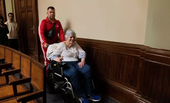 Beatriz Gelos, a woman suffering amyotrophic lateral sclerosis (ALS) leaves the Senate after attending part of a session on a bill to legalize euthanasia, which was approved by the lower house, in Montevideo, Uruguay, Wednesday, Oct. 15, 2025. (AP Photo/Matilde Campodonico)