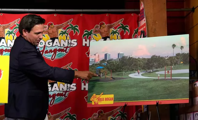 Florida Gov. Ron DeSantis displays an artist rendition of a fitness trail in honor of wrestling legend Hulk Hogan Friday, Oct. 3, 2025, in Clearwater, Fla. (AP Photo/Chris O'Meara)
