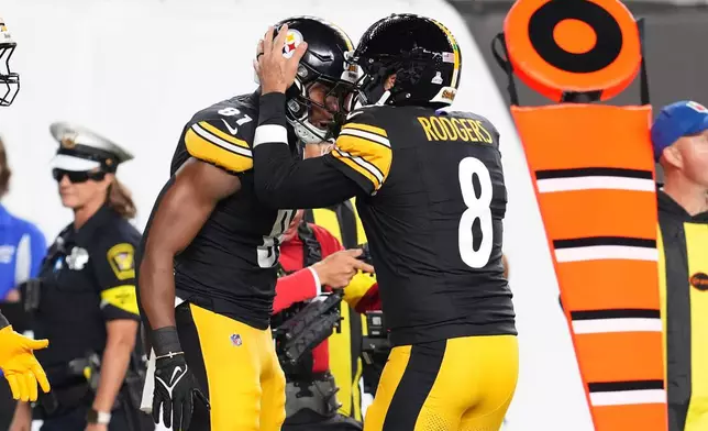 Pittsburgh Steelers tight end Jonnu Smith (81) and quarterback Aaron Rodgers (8) celebrate after connecting for a touchdown during the first half of an NFL football game against the Cincinnati Bengals in Cincinnati, Thursday, Oct. 16, 2025. (AP Photo/Jeff Dean)