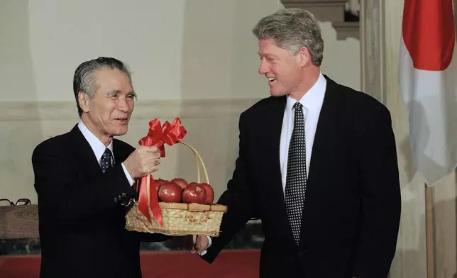 FILE - Japanese Prime Minister Tomiichi Murayama holds a basket of Washington state apples which President Bill Clinton gave him prior to the start of their joint news conference at the White House in Washington, Jan. 11, 1995. (AP Photo/Greg Gibson, File)