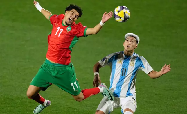Morocco's Ilias Boumassaoudi, left, and Argentina's Ian Subiabre vie for the ball during the FIFA U-20 World Cup final soccer match in Santiago, Chile, Sunday, Oct. 19, 2025. (AP Photo/Gustavo Garello)