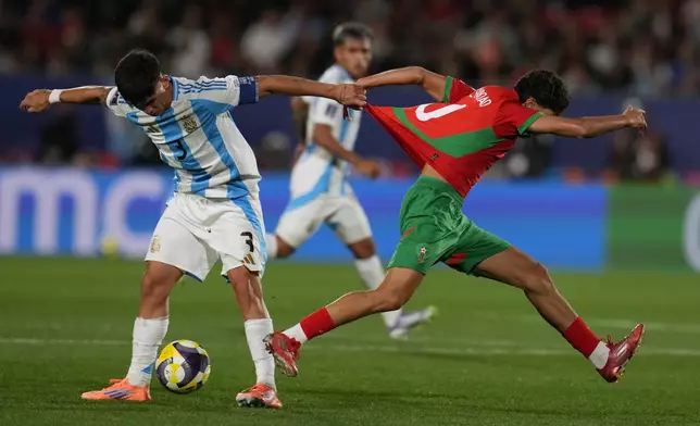 Argentina's Julio Soler pulls the jersey of Morocco's Saad El Haddad during the FIFA U-20 World Cup final soccer match in Santiago, Chile, Sunday, Oct. 19, 2025. (AP Photo/Esteban Felix)