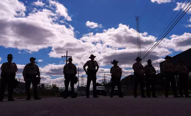 Illinois State Police stand guard as people including members of the Coalition for Spiritual and Public Leadership (CSPL) gather outside a U.S. Immigration and Customs Enforcement facility in Broadview, Ill., Saturday, Oct. 11, 2025. (AP Photo/Adam Gray)