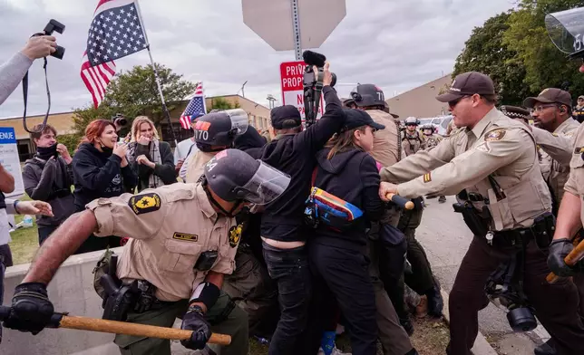 Illinois State Police and Cooks County Sheriffs move in to detain protesters outside the U.S. Immigration and Customs Enforcement facility in Broadview, Ill., Saturday, Oct. 11, 2025. (AP Photo/Adam Gray)